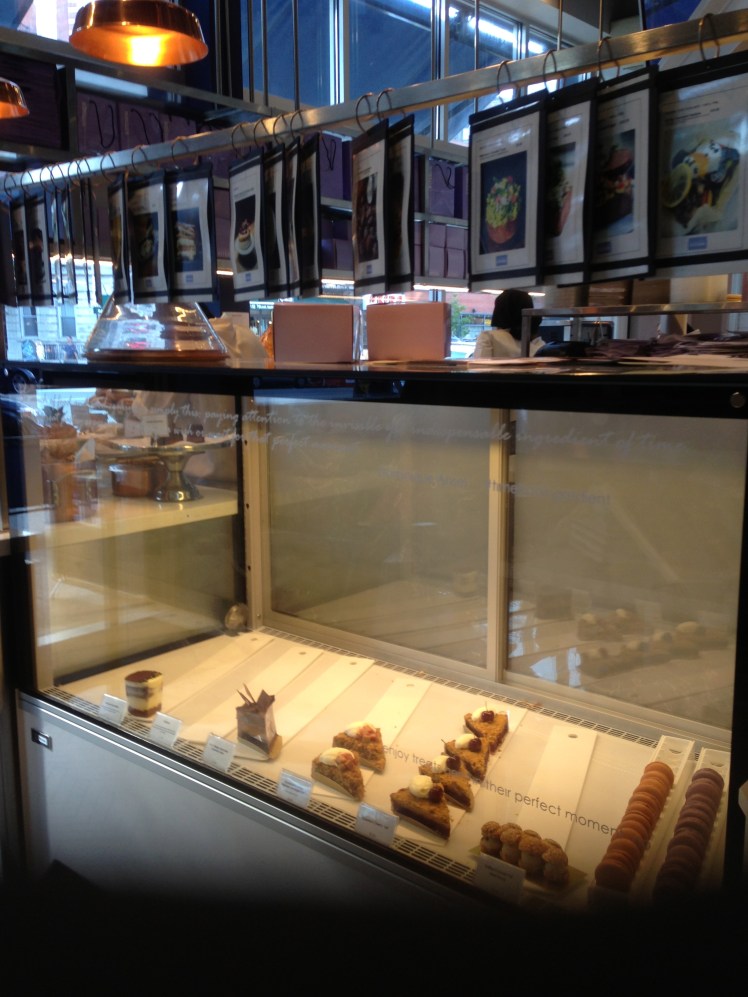 cake display with photos of the menu hang above it